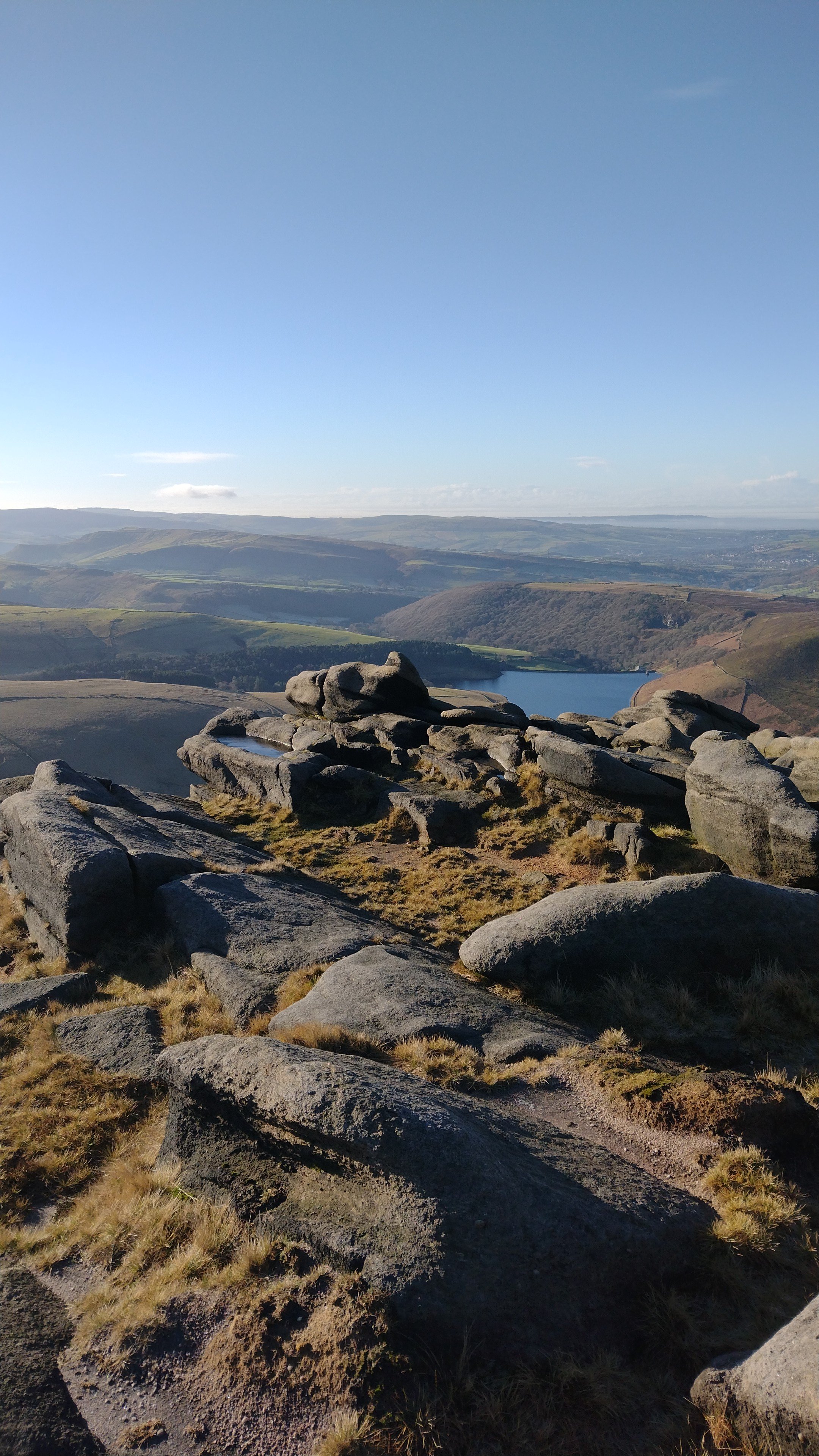 Gritstone boulders on Kinder Scout with reservoir views